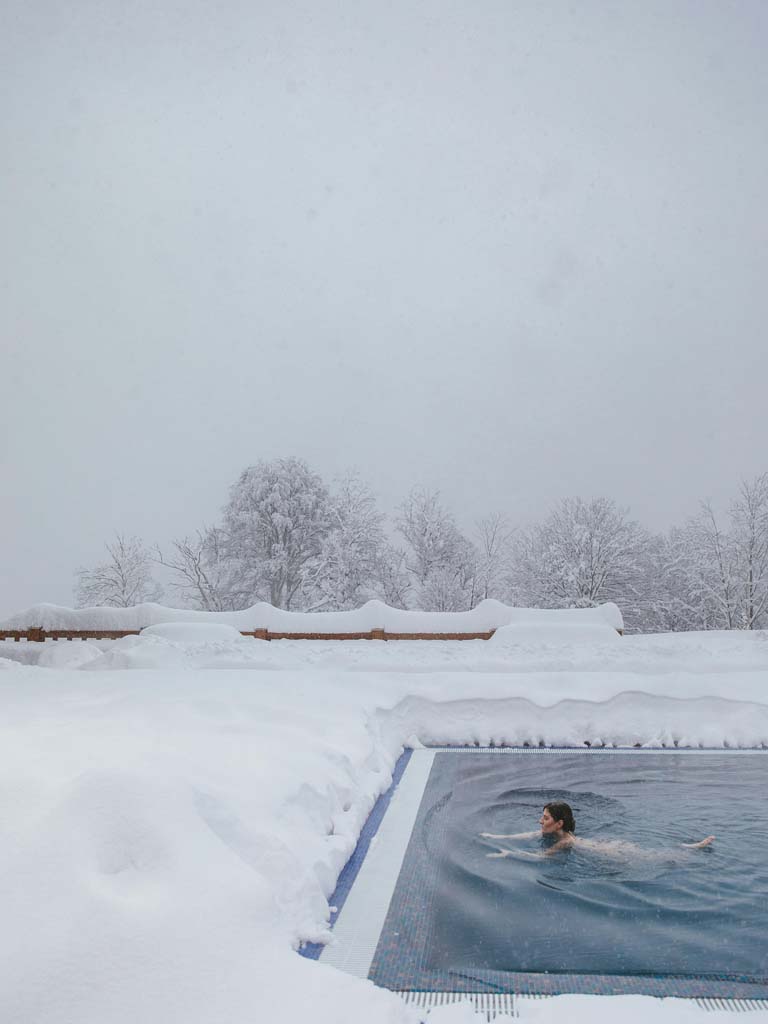 A lady in an ice bath outside in the snow