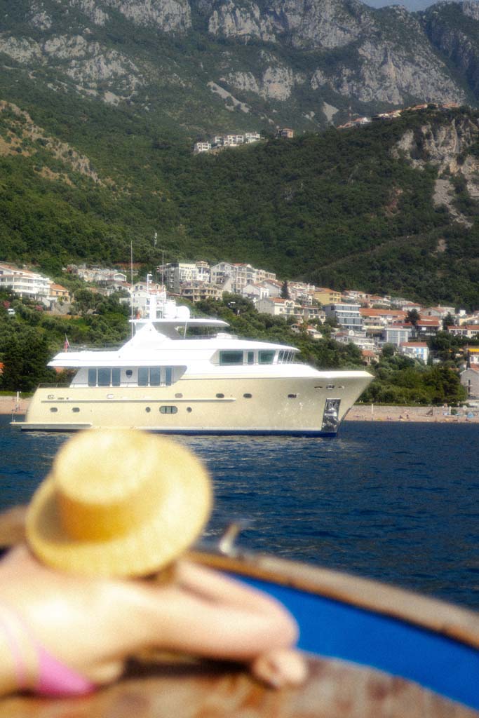 A lady on a yacht staring at another yacht